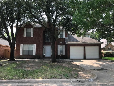 a red brick house with white garage doors